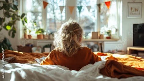 A child sits on a cozy bed, gazing out the window, embodying innocence and curiosity, surrounded by sunlight and warmth in a serene and inviting setting. photo