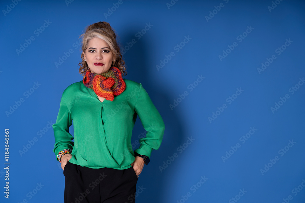 Confident businesswoman posing with hands in pockets on blue background Confident businesswoman posing with hands in pockets on blue background