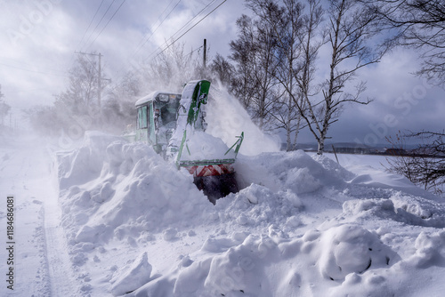 View of a snow clearing machine removing snow in a beautiful winter landscape with trees and a frozen lake, Abashiri, Hokkaido Prefecture, Japan. photo