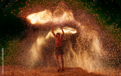 Penang, Malaysia - 13 September 2024: View of a dynamic fire performance with twirling sparks by a skilful acrobat on the beach at night, Penang, Malaysia.