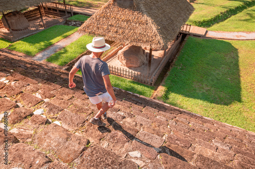 A Latin tourist descends the steps of a Mayan pyramid, located in the city of Quiriguá.