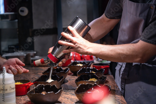 Fototapeta Naklejka Na Ścianę i Meble -  Utilisation de siphon pour finaliser un plat en cuisine. Dépose de la mousse dans le plat avant envoi en salle. Technique utilisée par un chef cuisinier. 