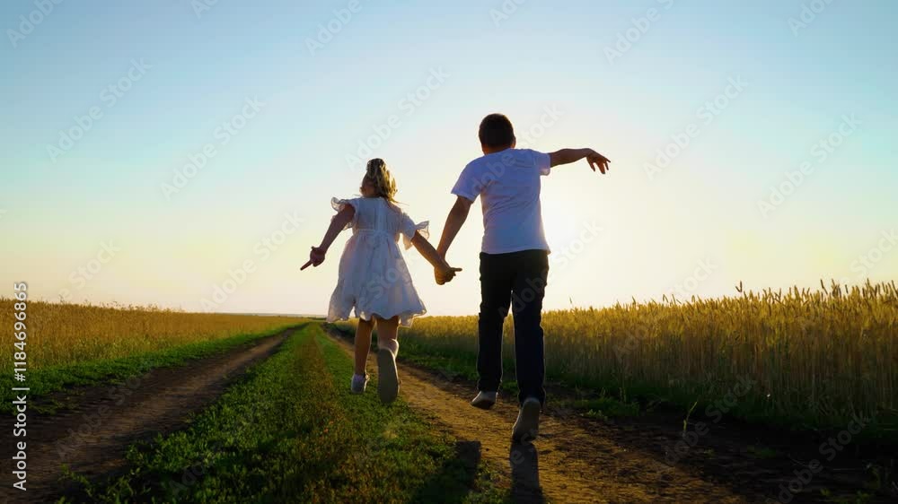 Children in together run through wheat field at sunset. Kids boy girl play fun run holding hands. Superhero kid. Happy family. Carefree child in summer. Childhood dream concept. Kids nature vacation. Children in together run through wheat field at sunset. Kids boy girl play fun run holding hands. Superhero kid. Happy family. Carefree child in summer. Childhood dream concept. Kids nature vacation.