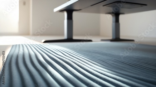 A close-up view of a textured rug under a modern desk in a bright, minimalist space.