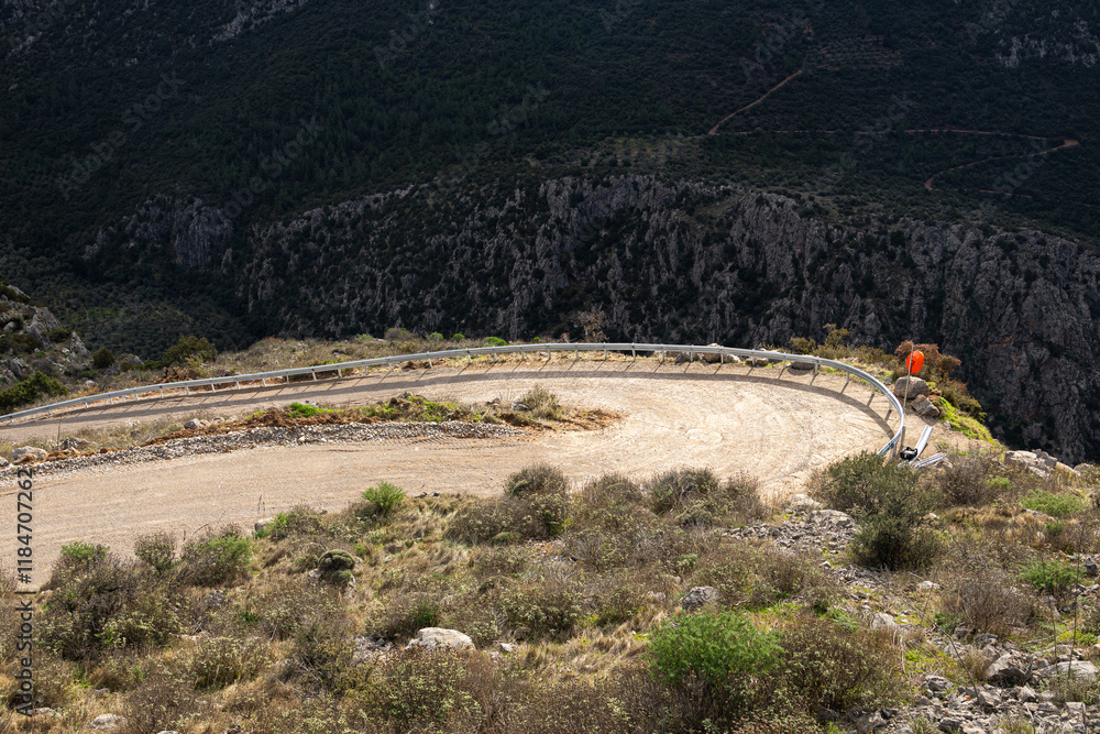 Curved dirt road in the mountains. View from above to a waving off road route on the hills.