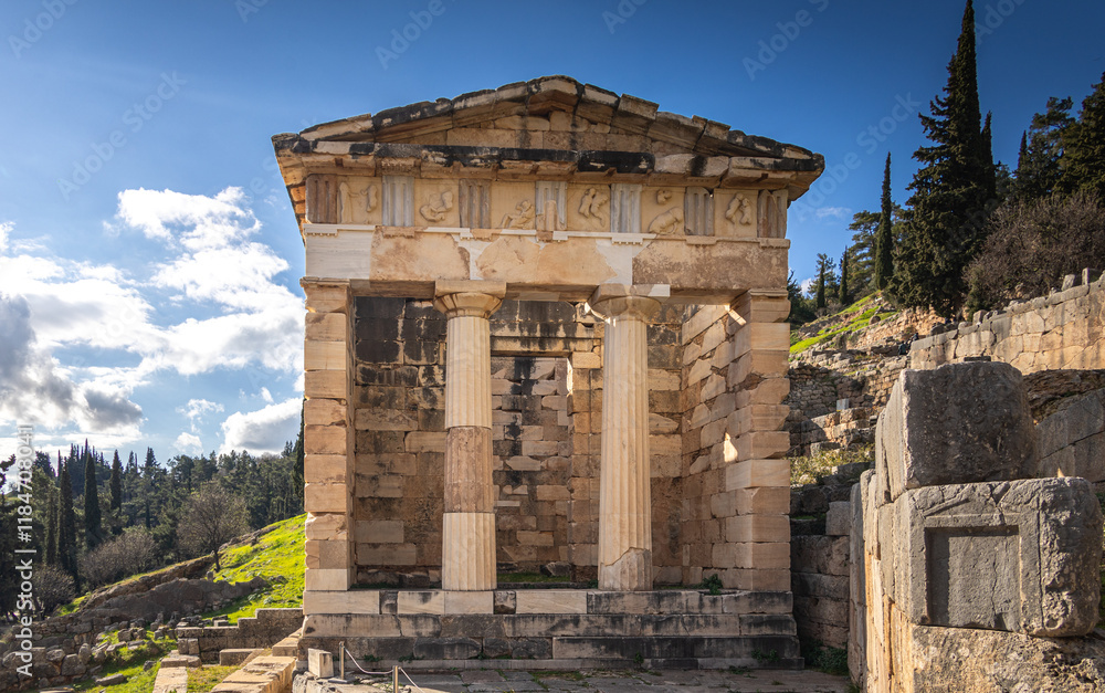 The Athenian Treasury from Delphi Archaeological Site. Wide photo with this historical cultural construction from Delphi, part of Greek history. Photo during a sunny day. Travel to Greece.