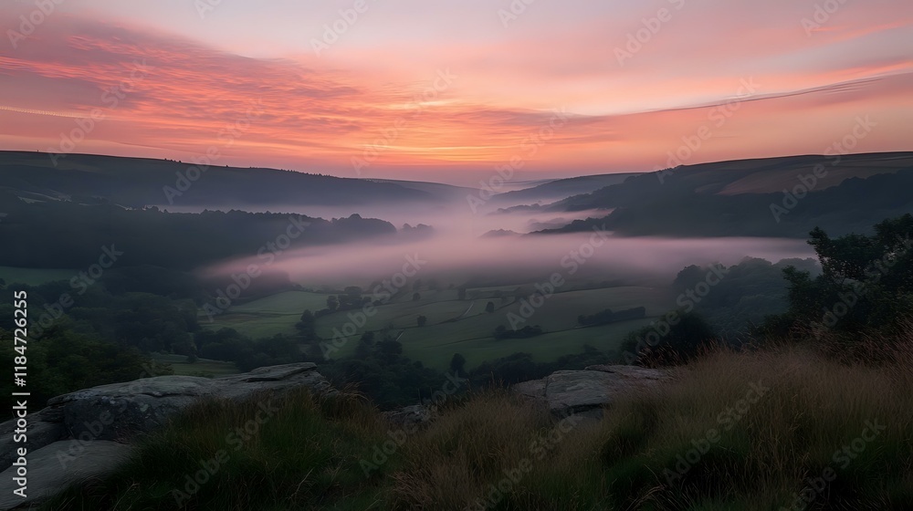 Obraz premium Scenic hilltop view overlooking a misty valley at sunrise, with soft pink and orange hues in the sky
