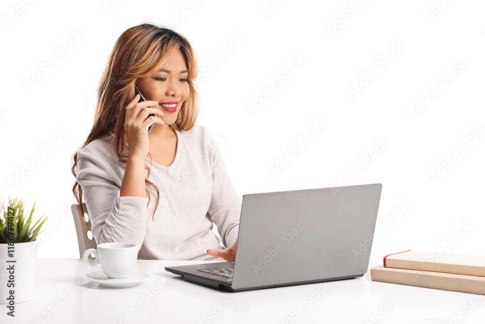 Young asian woman working on a laptop computert and making a phone call Young asian woman working on a laptop computert and making a phone call