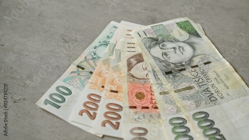 Czech koruna banknotes displayed on a concrete surface highlight the currency from the czech republic, featuring various denomination notes. photo