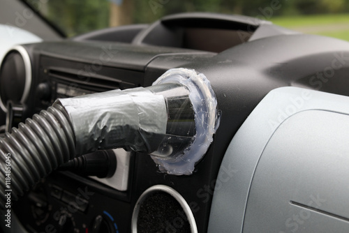 DIY back seat car ventilation for cooling down or heating. Vehicle backseat air conditioning system. Vacuum hose attached to middle console vent to push hot or cold air to the back. Selective focus.