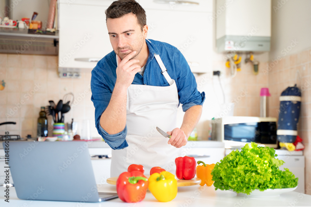 One man is learning to cook watching video online One man is learning to cook watching video online