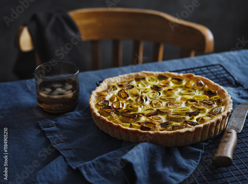 Mouth Watering Savory Tart With Leeks and a Refreshing Drink on a Rustic Table Setting photo