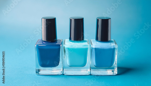 Set of colorful nail polish bottles on blue background. Various shades. Beauty concept.