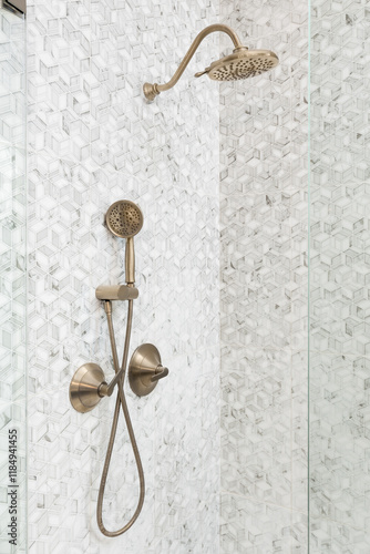 Фотография A shower with marble mosaic tiles in a square pattern with a gold showerhead