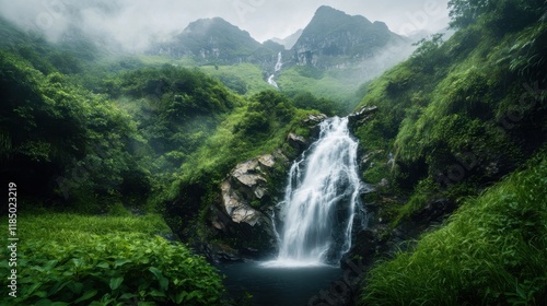 Misty waterfall cascades down lush rainforest mountain