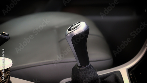 Modern car interior showing the gear stick and a coffee cup