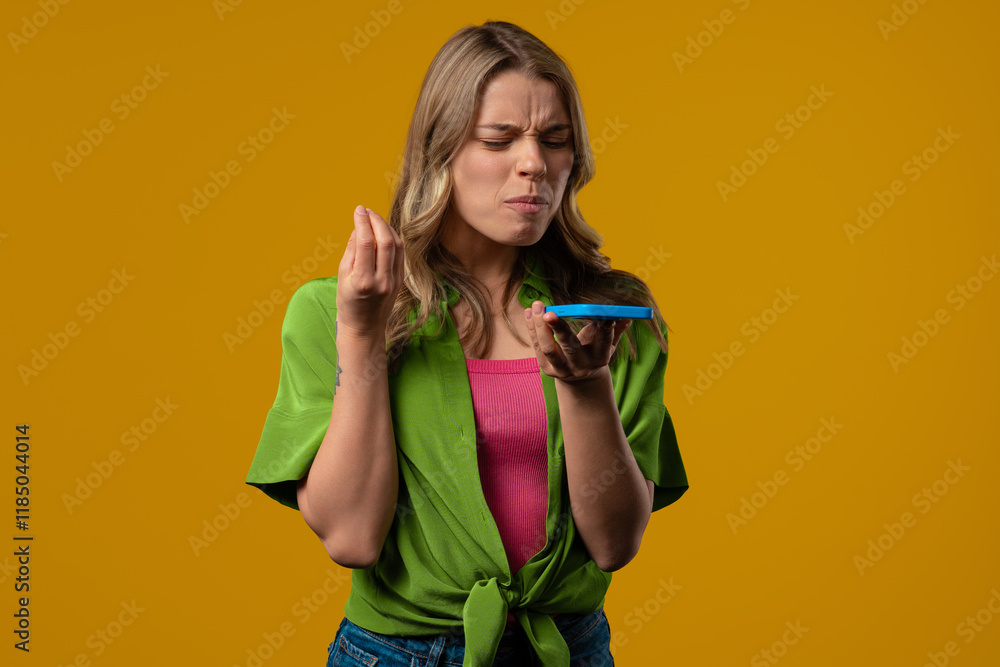 Annoyed young student woman quarreling while talking on mobile phone. Angry lady, stress. Yellow studio background. Conflict, dispute, negative. Annoyed young student woman quarreling while talking on mobile phone. Angry lady, stress. Yellow studio background. Conflict, dispute, negative.