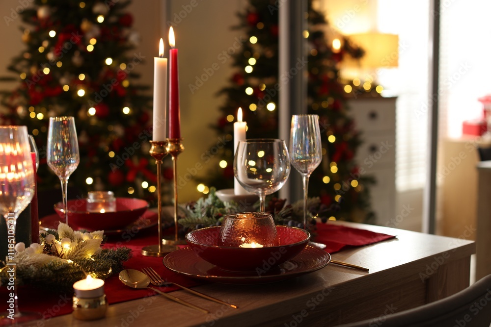 Christmas table setting with stylish dishware, glasses and burning candles in festive decorated room Christmas table setting with stylish dishware, glasses and burning candles in festive decorated room