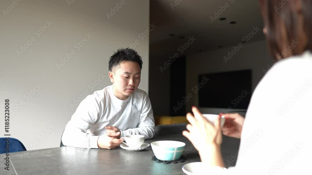 A Japanese couple, a woman in her 30s and a man in his 20s, are enjoying afternoon tea time at home. Slow motion video. A Japanese couple, a woman in her 30s and a man in his 20s, are enjoying afternoon tea time at home. Slow motion video.
