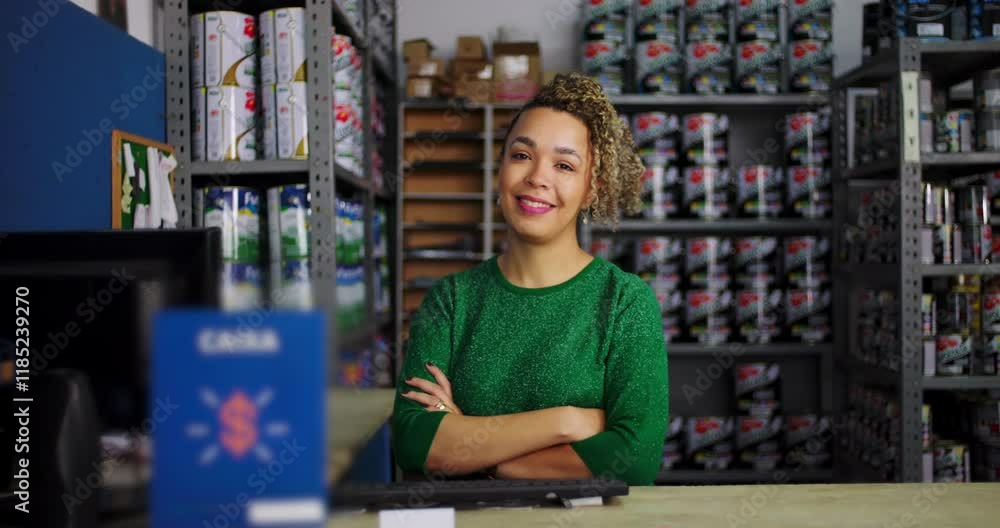 Female entrepreneur standing at the counter in a hardware store, confidently smiling with shelves of paint and supplies in the background Female entrepreneur standing at the counter in a hardware store, confidently smiling with shelves of paint and supplies in the background