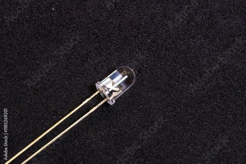 A clear LED with gold pins on a black background photo