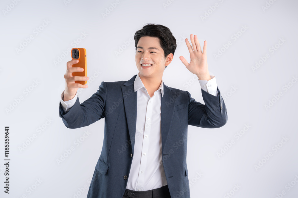 Portrait of young Asian business man using phone and posing on white background Portrait of young Asian business man using phone and posing on white background
