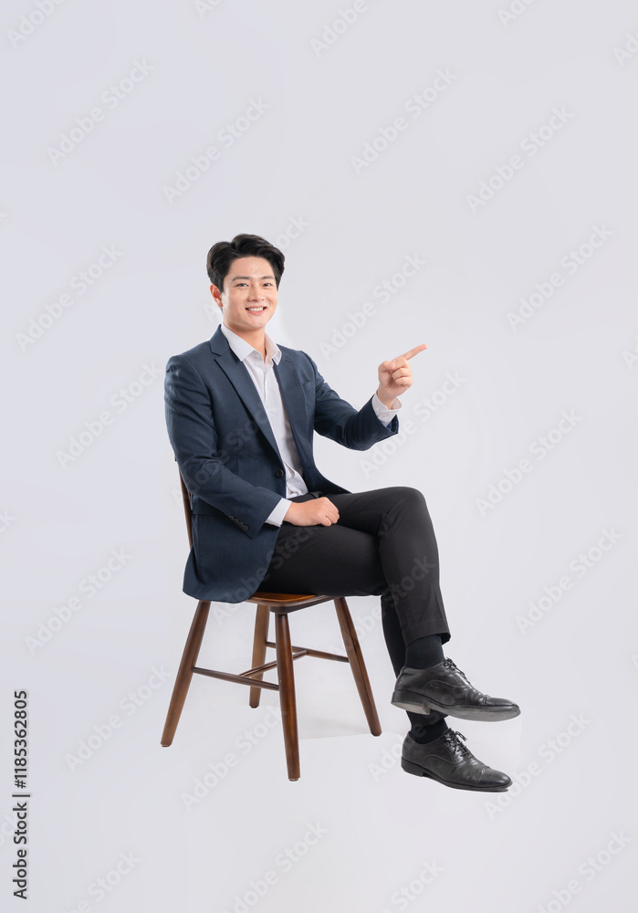 Full body image of young Asian business man sitting in chair on white background Full body image of young Asian business man sitting in chair on white background