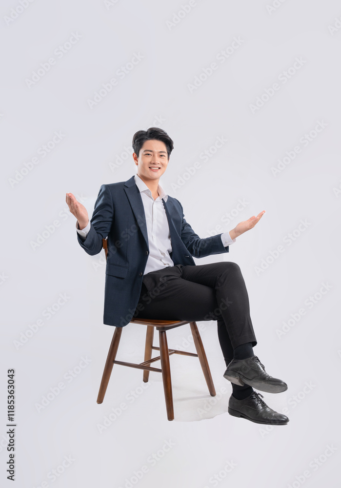 Full body image of young Asian business man sitting in chair on white background Full body image of young Asian business man sitting in chair on white background