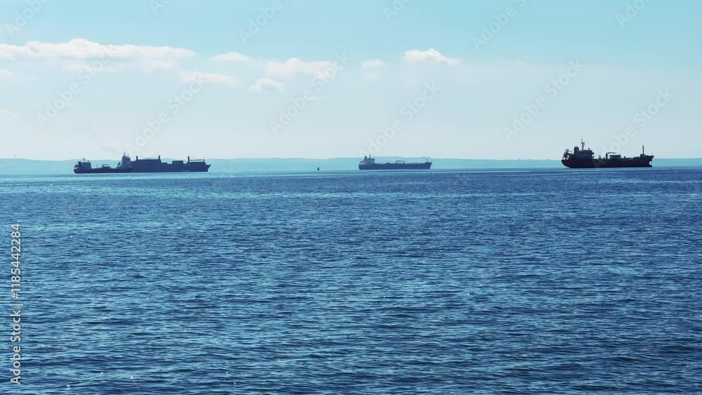 Three cargo ships on sea horizon approach Thessaloniki pier in Greece Three cargo ships on sea horizon approach Thessaloniki pier in Greece