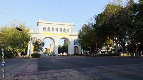 Guadalajara, Jalisco, México - Jan 8 2025: Timelapse, cars pass by. Majestic neoclassical arches built in 1942 in commemoration of the 400th anniversary of Guadalajara.
