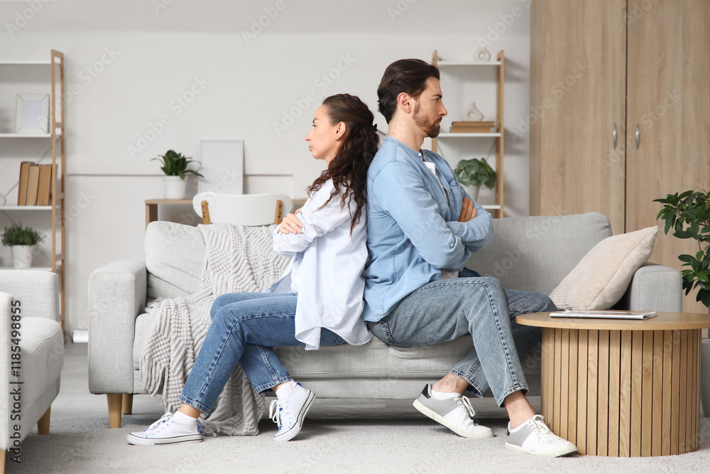 Offended couple sitting on sofa at home. Divorce concept Offended couple sitting on sofa at home. Divorce concept