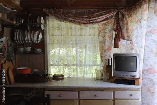 Light wooden kitchen interior with kitchen utensils on the shelves and on the wall. Beautiful kitchen interior design.