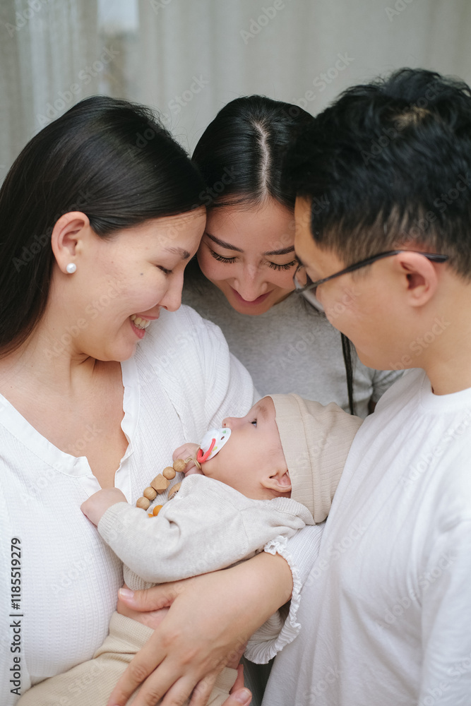 Family embracing cute infant child boy with love in the room. Smiling asian mother, father and aunt holding sleeping newborn baby. Slow-motion. Family embracing cute infant child boy with love in the room. Smiling asian mother, father and aunt holding sleeping newborn baby. Slow-motion.