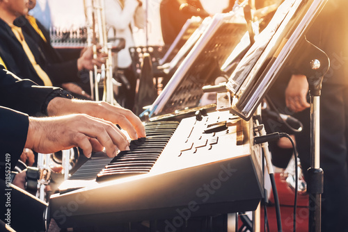 Canvas Print Pianist male hands playing electric piano with the band on stage