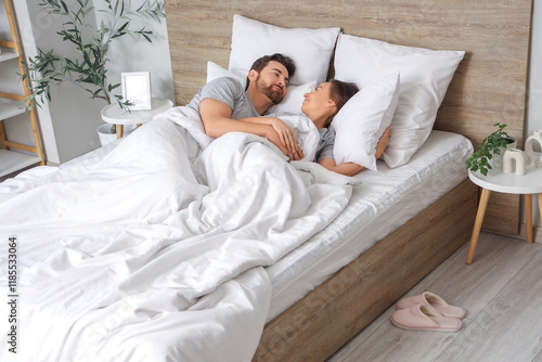 Morning of loving couple waking up in bedroom
