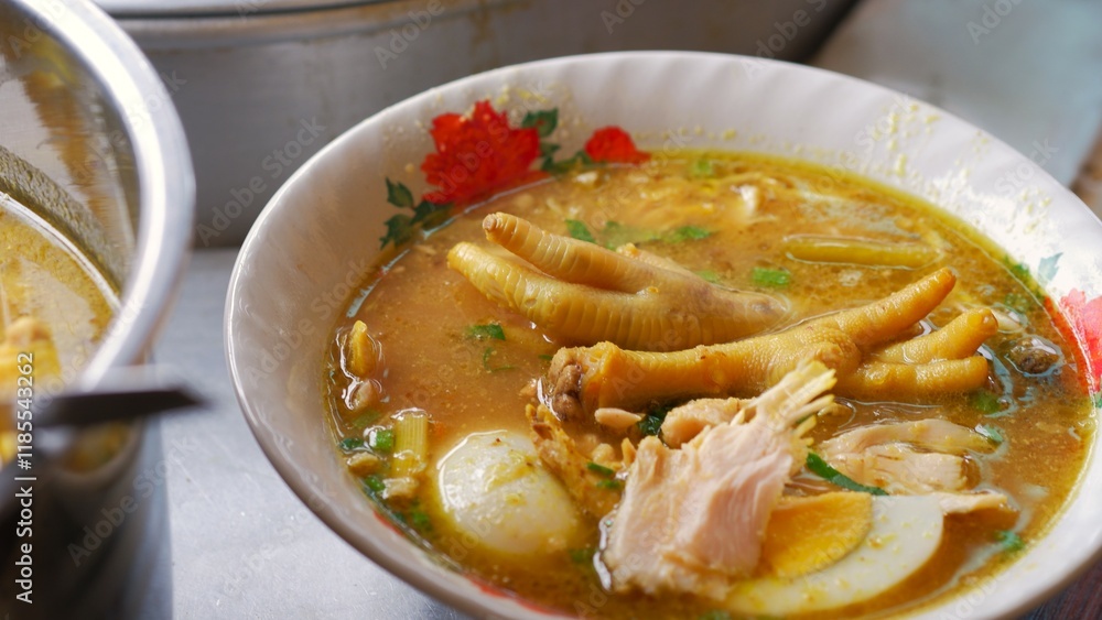 Chicken soup with shredded chicken, chicken feet, eggs, sliced cabbage, vermicelli in broth. Indonesia food. Chicken soup with shredded chicken, chicken feet, eggs, sliced cabbage, vermicelli in broth. Indonesia food.