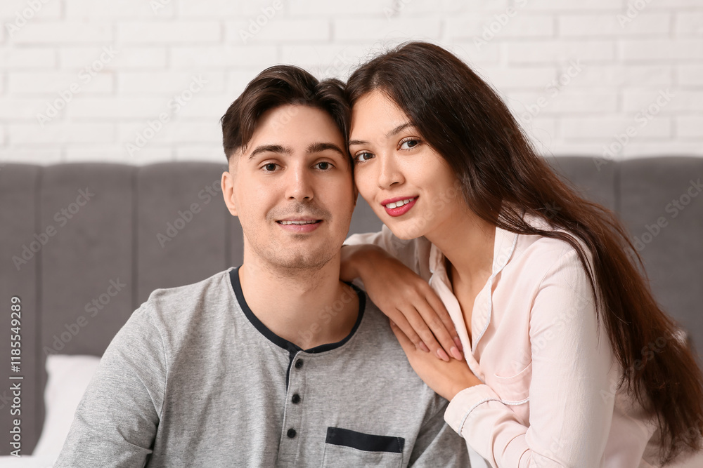 Young couple sitting together on bed Young couple sitting together on bed