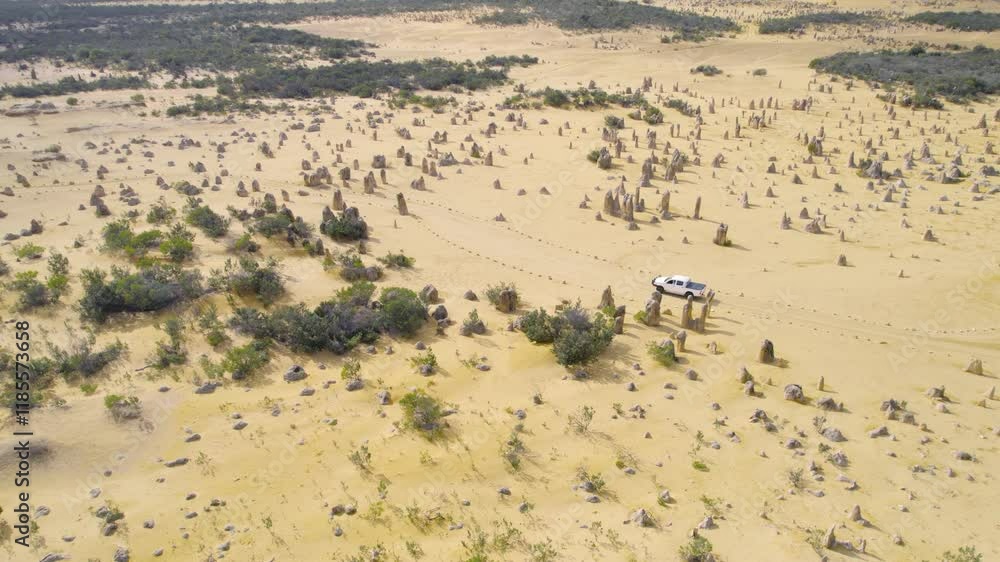 Aerial View Of a Pickup Truck Driving Through The Limestone Structures Of The Pinnacles Desert In Western Australia. Aerial View Of a Pickup Truck Driving Through The Limestone Structures Of The Pinnacles Desert In Western Australia.