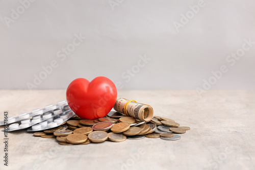 Red heart with money and pills on grey background photo