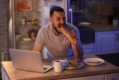 Hungry young man with lapto...