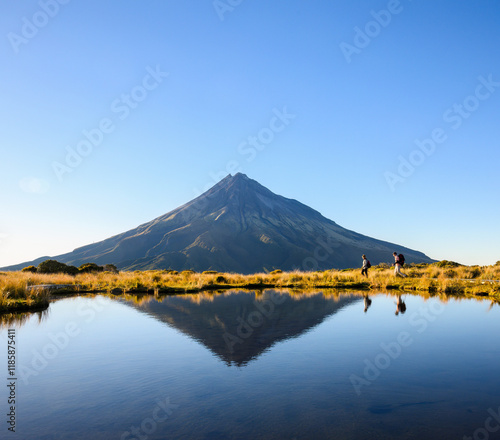 Couple hiking the Pouakai circuit. Mt Taranaki under the clear blue sky. New Zealand. photo