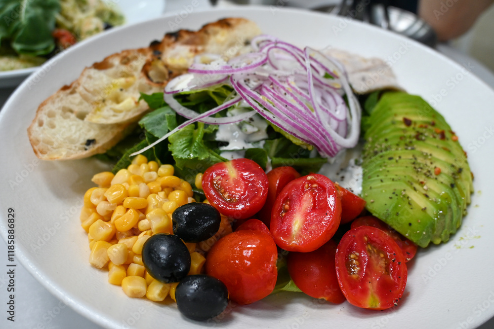 Salad made with fresh vegetables such as onions, tomatoes, avocados, olives, corn, and baguette bread Salad made with fresh vegetables such as onions, tomatoes, avocados, olives, corn, and baguette bread