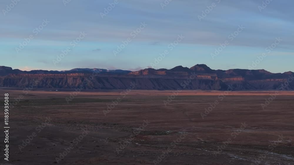 A sweeping view of Moab’s desert plain with rugged cliffs under soft dawn light A sweeping view of Moab’s desert plain with rugged cliffs under soft dawn light