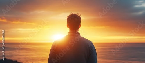 A brunette man stands with ...