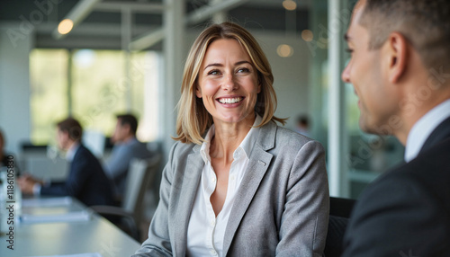 Smiling female business leader engaged in meeting, office collaboration