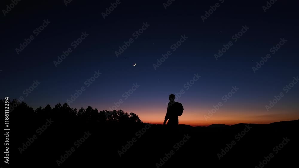 Silhouette of a man observing Milky Way stars, Moon and planets from a dark countryside location. Silhouette of a man observing Milky Way stars, Moon and planets from a dark countryside location.