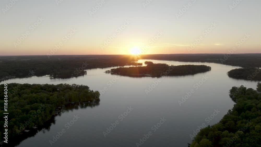 Aerial view of Balsam Lake, Wisconsin, showcasing a stunning sunset and tree-lined islands. Aerial view of Balsam Lake, Wisconsin, showcasing a stunning sunset and tree-lined islands.