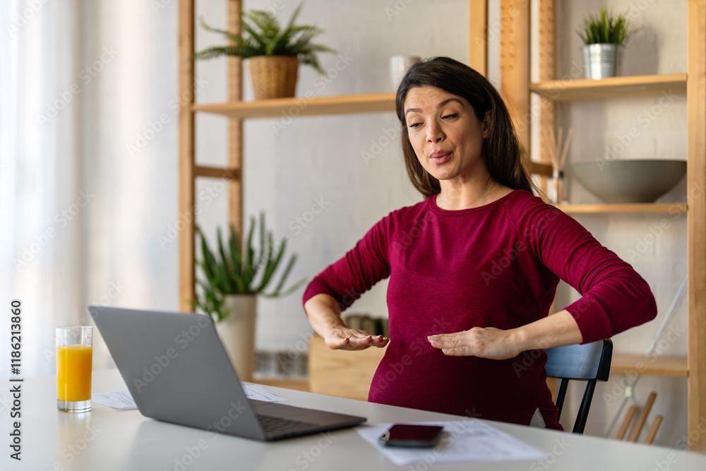 Pregnant woman using online app to practice breathing exercise while working from home. Pregnant woman using online app to practice breathing exercise while working from home.