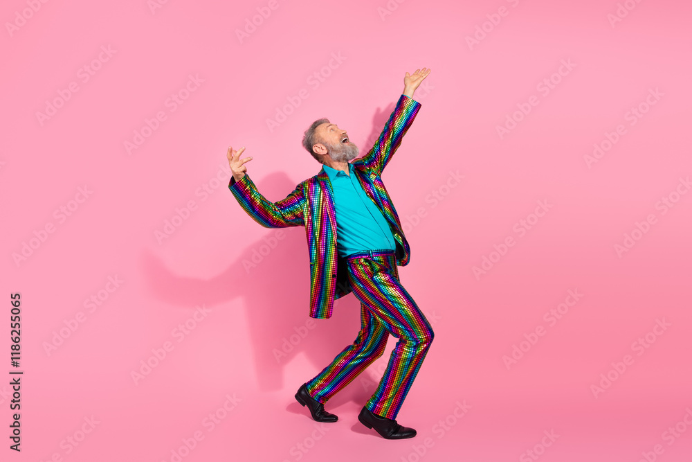 Elderly man in vibrant suit posing on pink background expressing happiness and individuality Elderly man in vibrant suit posing on pink background expressing happiness and individuality