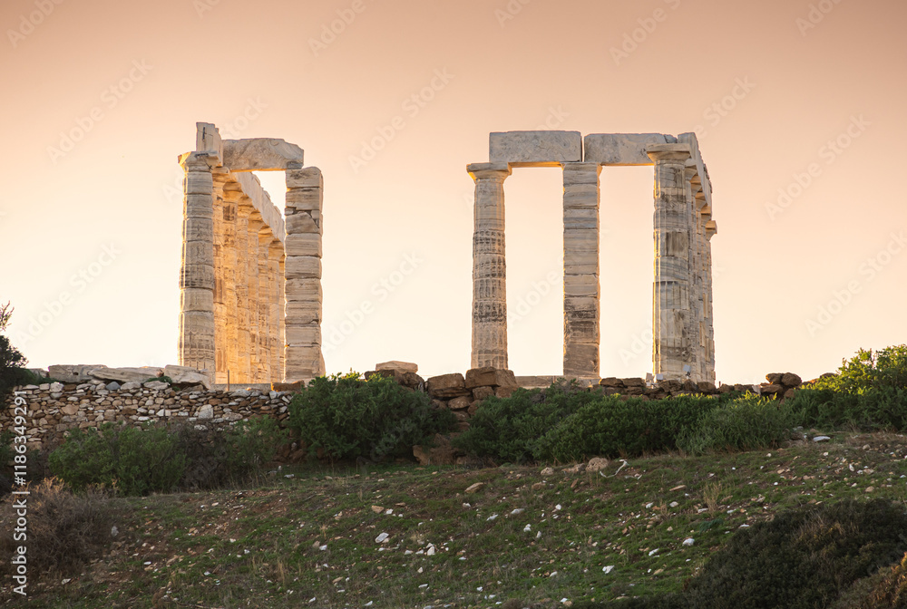Temple of Poseidon. Beautiful landscape with warm light sky before sunset over Poseidon Temple at Sounion Cape from Greece. Visit and travel to Greece.